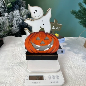 Detailed view of Halloween wood craft with ghost and pumpkin weighing 86 grams on scale
