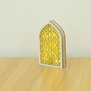 Detail of wooden LED lantern with intricate geometric cutouts and golden glittery backing