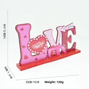 Détail de la décoration LOVE en bois de 14cm avec motifs ondulés roses et paillettes