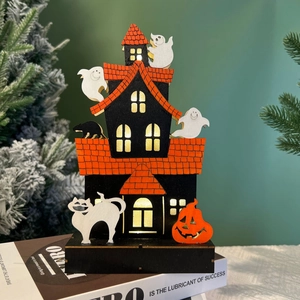 Close-up of wooden Halloween house with warm LED lights, ghosts and pumpkin detail