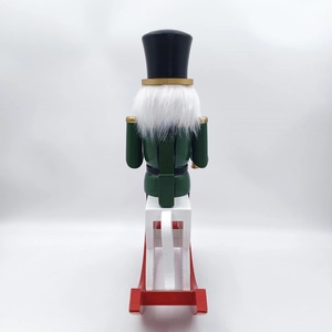 Rear view detail of a traditional 30cm green wooden nutcracker on a white rocking horse