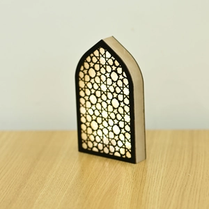 Close-up of wooden LED arch lamp with intricate geometric star patterns and warm glow