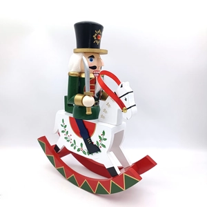 Detail of traditional wooden nutcracker soldier on rocking horse with green uniform