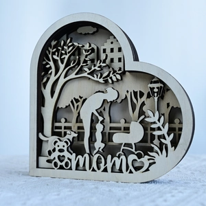 Detail of 3D layered wooden heart carving with mother and child silhouette and mom text