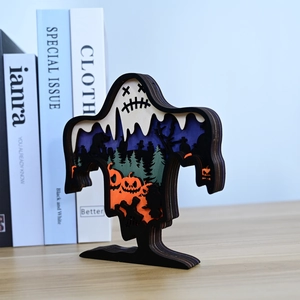 Detail of multi-layered wooden Halloween ghost carving with pumpkin and forest scene