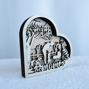 Detail of multi-layered wooden heart ornament with laser-cut trees and Mom text