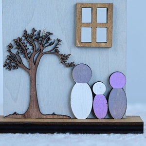 Detail of wooden family house ornament with laser-cut tree and Nordic minimalist style