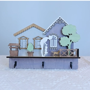 Detail of wooden wall decor featuring family silhouettes and three black utility hooks