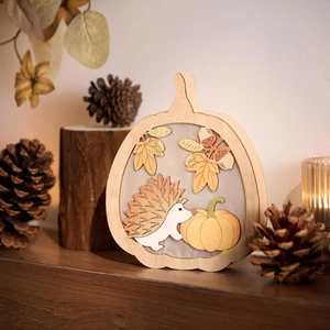 Détail d'une citrouille en bois multicouche sculptée avec hérisson et feuilles d'érable