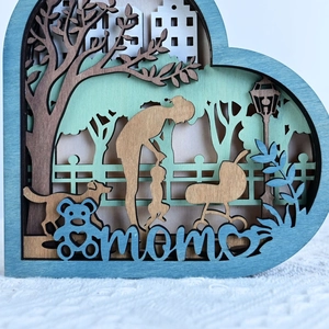 Macro detail of multilayer heart-shaped wooden Mom ornament with 3D carving