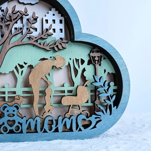 Detail of multi-layered wooden gift with mom silhouette and laser-cut scenery