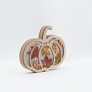 Detail of multi-layer wooden pumpkin decor with hollow maple leaf design and LED lighting