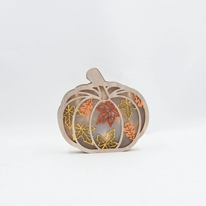 Detail of pumpkin wooden light featuring glowing autumn maple leaves for fall home decor