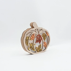 Detailed side view of a pumpkin wood craft ornament with multi-layer maple leaf design