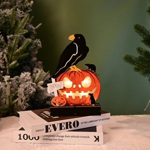 Detail of wooden Halloween crow on glowing pumpkin light with BOO sign and LED glow