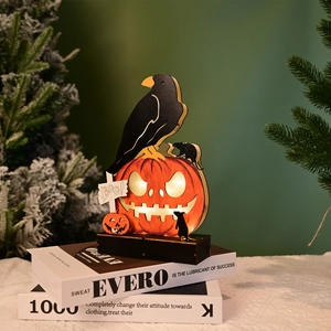 Detail of a lighted Halloween wooden crow and pumpkin table ornament with warm LED glow