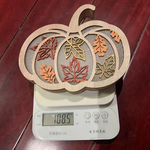 Top view of hollowed wooden pumpkin decoration with maple leaves on a digital scale