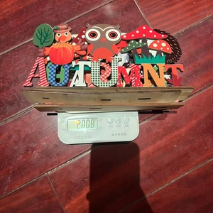 Detail of wooden Autumn table decor with owl, mushroom and turkey icons on a wood base