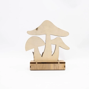 Detail of laser-cut wooden mushroom centerpiece with natural wood grain and burnished edges