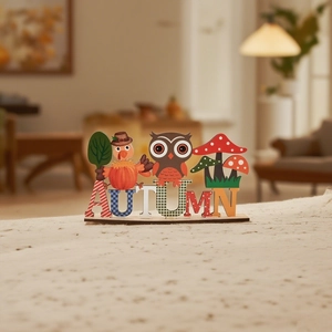 Detail of wooden Autumn table decor featuring turkey owl and mushroom icons on base