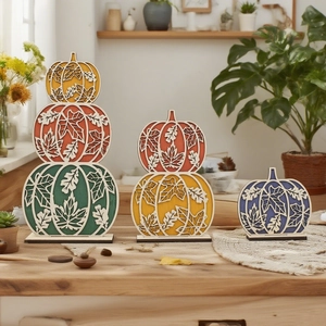 Close-up of laser-cut layered wooden pumpkins with autumn leaf patterns and stable bases
