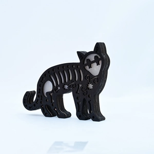 Detail of layered black wooden cat sculpture with hollow stars and moon carvings