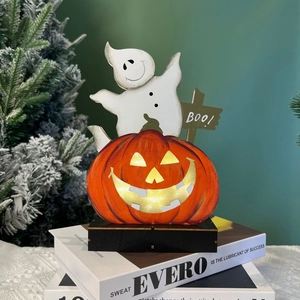 Detail of wooden Halloween LED ornament with glowing pumpkin and white ghost on base