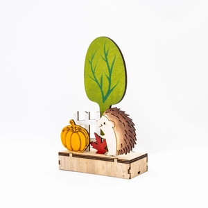 Dettaglio decorazione autunnale in legno intagliato con riccio e zucca su base