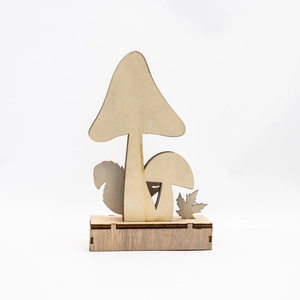Macro shot of laser-cut wooden mushroom desk decor with squirrel and maple leaf silhouettes