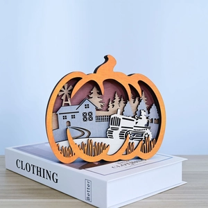 Close-up of layered wooden pumpkin carving with tractor and barn autumn scenery