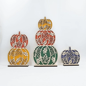 Detail of laser-cut hollow leaf patterns on autumn-themed wooden pumpkin table decor