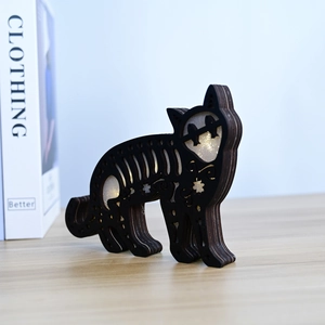 Detail of laser-cut wooden black cat LED lamp with warm glowing hollow rib patterns