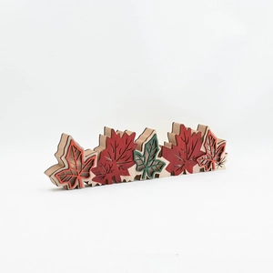 Close-up of laser-cut multi-layered wooden maple leaf decor in autumn colors for harvest festival