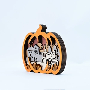 Detail of multi-layer wood carved pumpkin ornament with rustic rural scenery