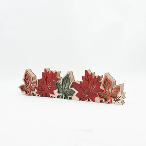 Detail view of multi-layered wooden maple leaf ornaments with gold glitter and autumn colors