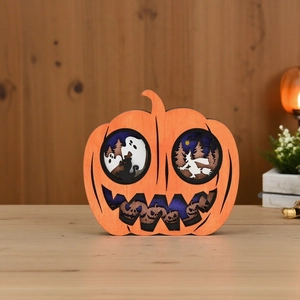 Detail of layered wooden Halloween pumpkin decor with ghost, witch and forest silhouettes