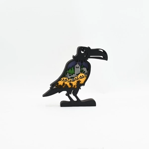 Detailed laser-cut crow silhouette with layered pumpkin and graveyard Halloween scene