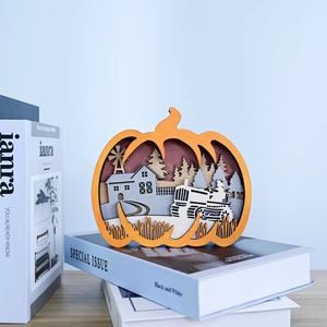 Detail of multi-layered wooden pumpkin ornament with a carved rural farmhouse scene