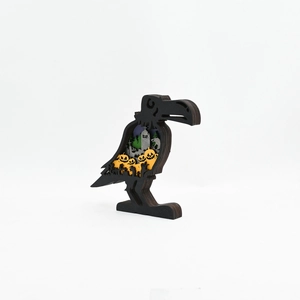 Detailed macro view of layered wooden raven carving with pumpkin and tombstone elements