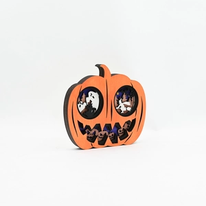 Detail of layered wood carving pumpkin ornament with ghost and witch motifs