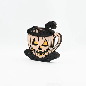 Detail of laser-cut wooden pumpkin coffee cup decor with layered ghost hands