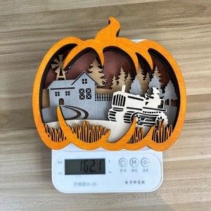 Macro view of carved wooden pumpkin decor showing weight of 162.1g on a digital scale