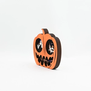 Detail of 3D layered wood pumpkin ornament with laser-cut ghost and castle silhouettes