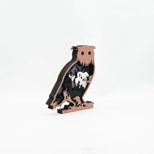 Detail of multi-layered wooden owl sculpture with carved Halloween haunted house scene