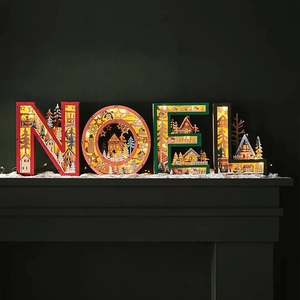 Detailed close-up of NOEL wooden LED letter lights with intricate winter village carvings