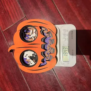 Detail shot of a 3D layered wooden Halloween pumpkin carving on a digital scale weighing 194.3g