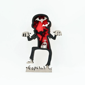 Close-up of laser-cut multilayer wooden zombie lamp with bats and RIP gravestone detail