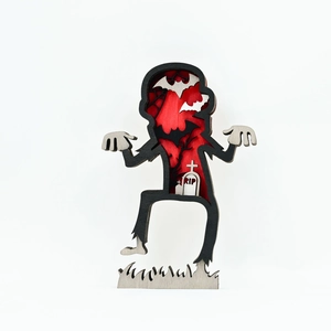 Detail of layered wood Halloween craft showing zombie silhouette with bat and RIP tombstone