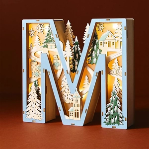 Macro view of M-shaped wooden 3D light box with winter forest scene and warm LED