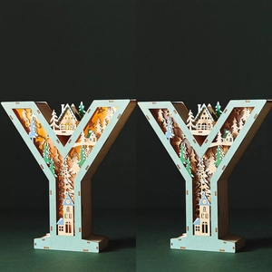 Detail of laser-cut wooden letter Y lamp with warm LED forest miniature landscape